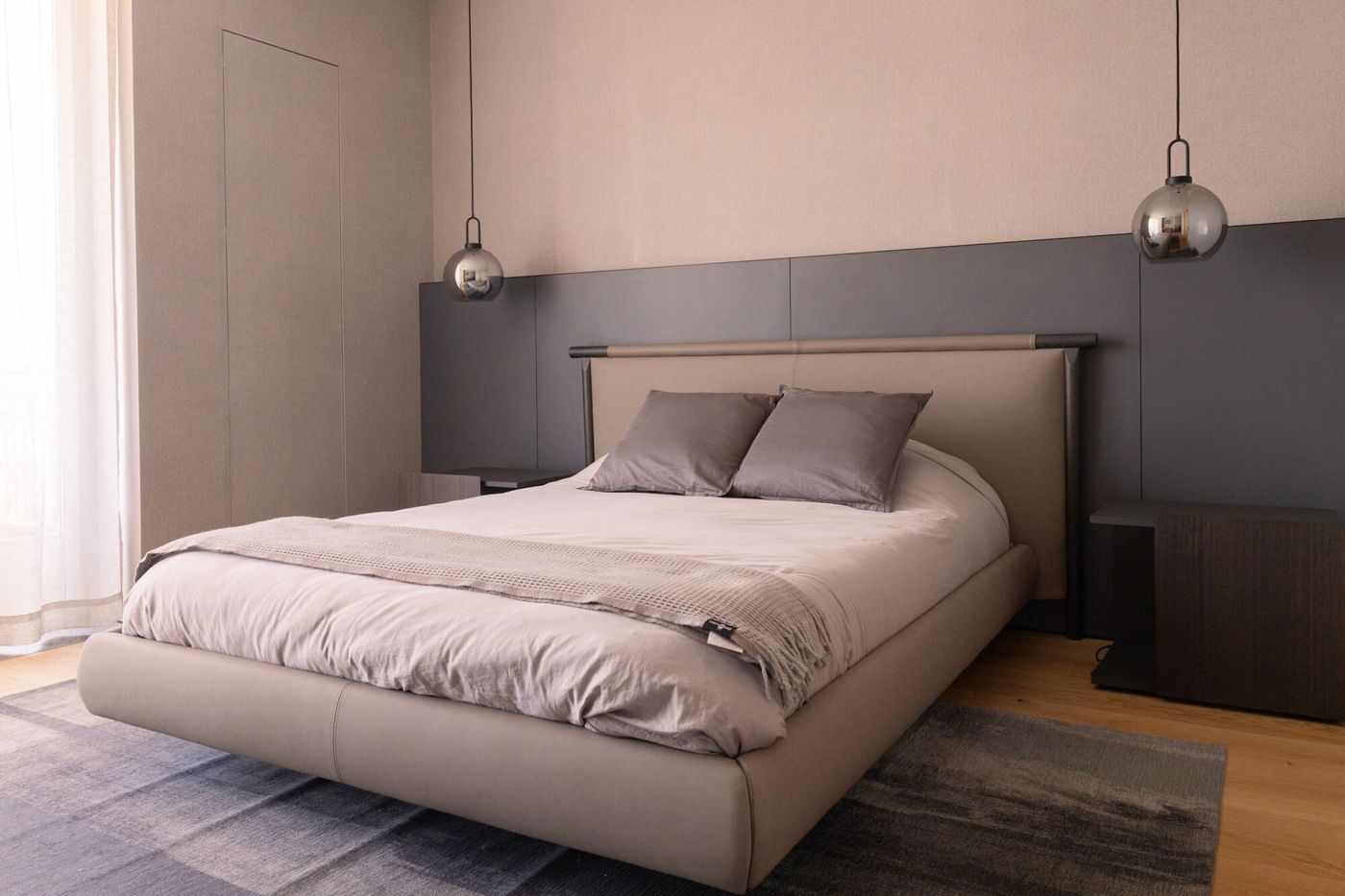 Recámara con cama y cabecera en tonos grises