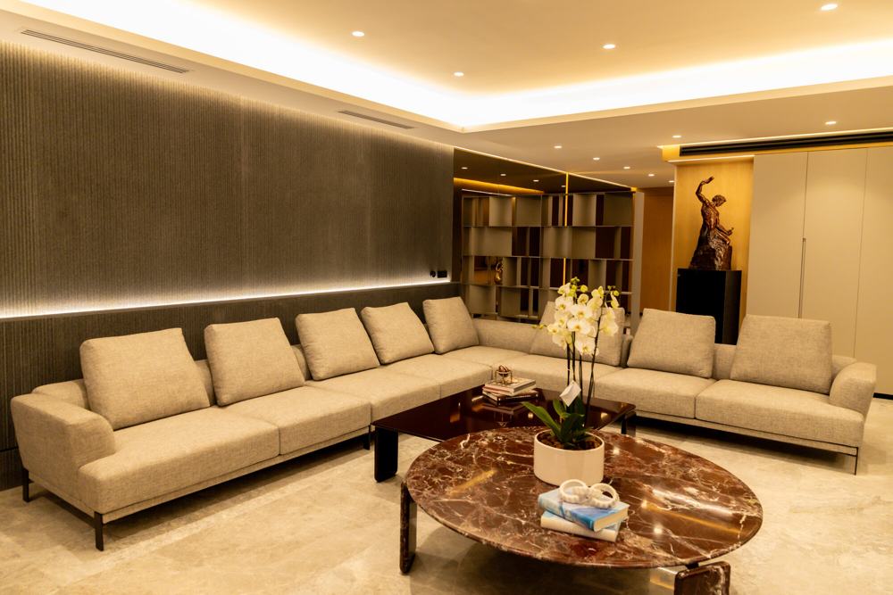 Sala amplia con sofá en L y mesa de mármol