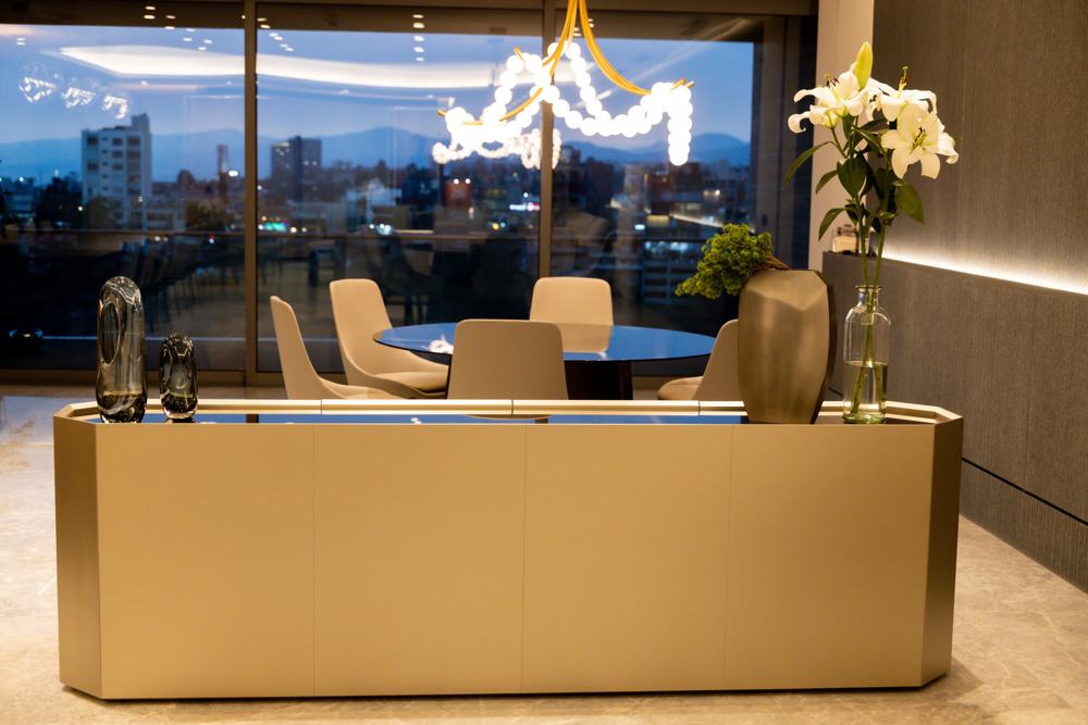 Credenza dorada frente a un comedor con vista nocturna