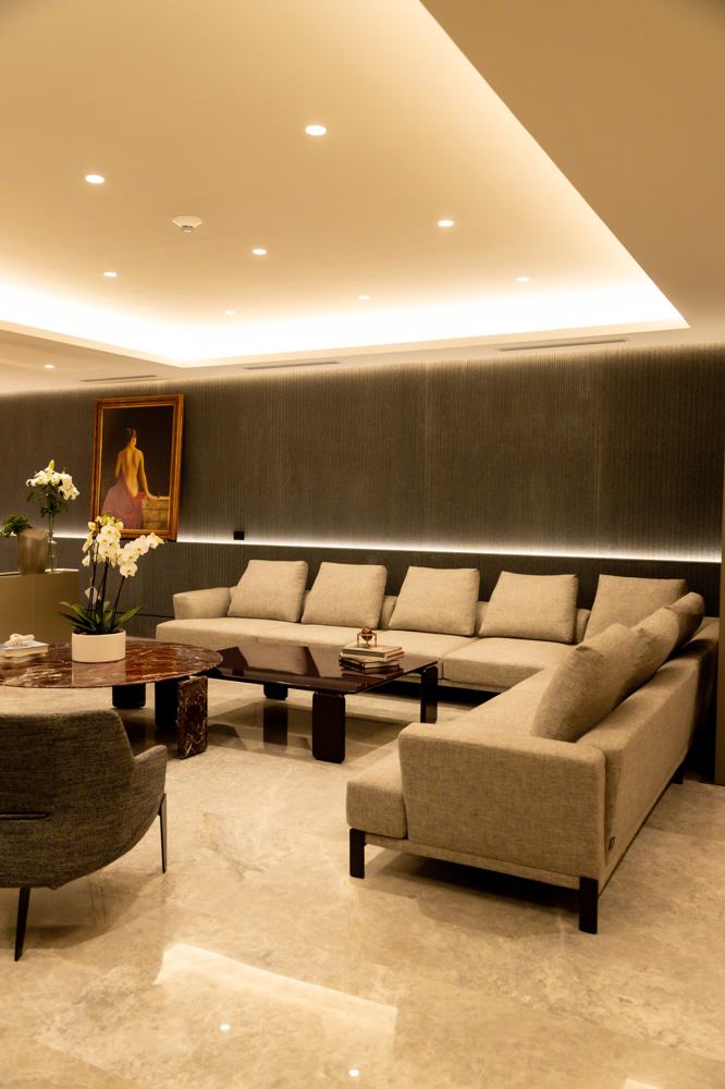 Sala con sofá en L, mesa de mármol y sillones