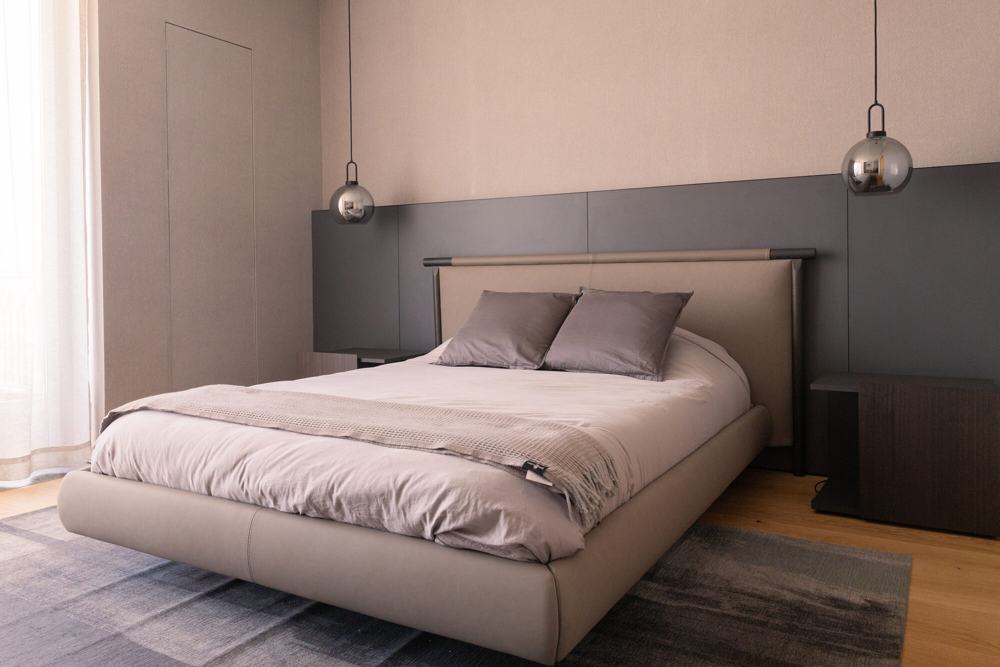 Recámara con cama y cabecera en tonos grises