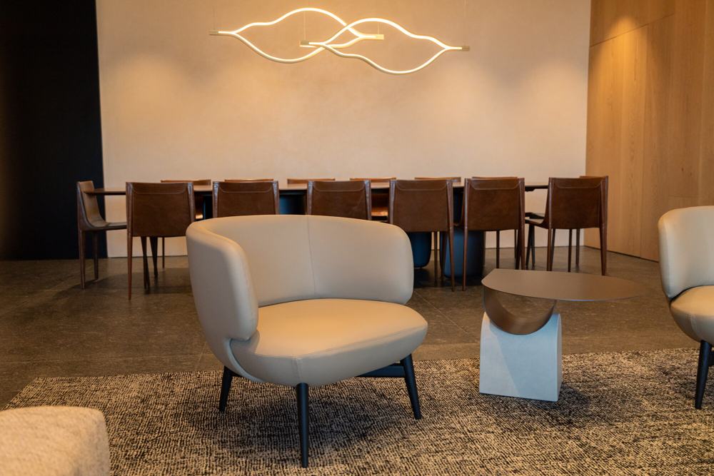 Sillón junto a mesa de comedor y lámpara escultórica